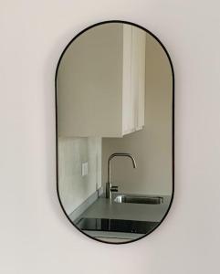 a mirror on a white wall with a sink at Atico con espléndida terraza in Comillas