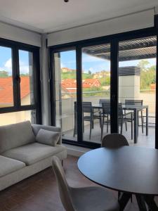 a living room with a couch and a table and chairs at Atico con espléndida terraza in Comillas