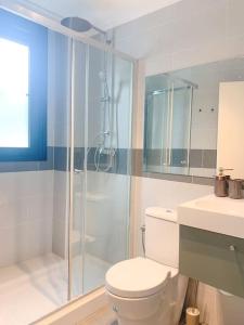a bathroom with a toilet and a glass shower at Atico con espléndida terraza in Comillas +9 photos