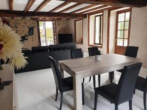 a dining room with a wooden table and chairs at La Maison du Lac Lavaud in Saint-Quentin-sur-Charente