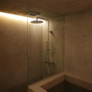 a shower stall with a glass door with a light at White House 熱海 in Atami