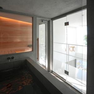 a bathroom with a large window and a bath tub at White House 熱海 in Atami