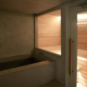 a bathroom with a bath tub with a mirror at White House 熱海 in Atami