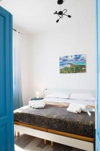 1 dormitorio con 1 cama con paredes blancas y puerta azul en Tesori del Sinis en Càbras
