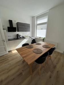 una mesa de madera en una cocina con suelo de madera en Wohlfühl-Oase 2.0, en Herne