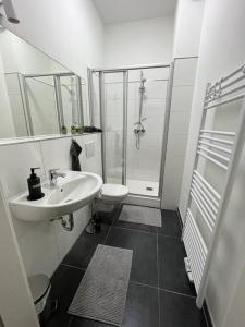 y baño blanco con lavabo y ducha. en Wohlfühl-Oase 2.0, en Herne