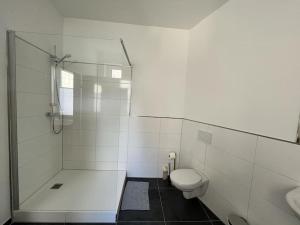 een witte badkamer met een douche en een toilet bij Wohlfühl-Oase 2.0 in Herne
