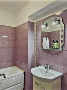 een badkamer met een wastafel, een spiegel en een bad bij Studio modern. in Boekarest