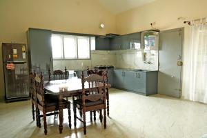 a kitchen with a table and chairs in a room at Chimneys Homestay - Full House, Near to Falls & Trek in Sakleshpur