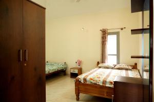 a bedroom with two beds and a window at Chimneys Homestay - Full House, Near to Falls & Trek in Sakleshpur
