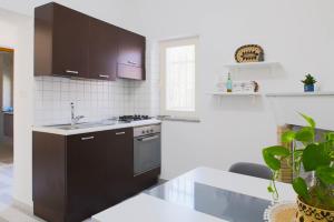 a kitchen with black cabinets and a sink at Tesori del Sinis in Càbras +61 photos