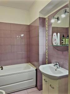 a bathroom with a white tub and a sink at Studio modern. in Bucharest