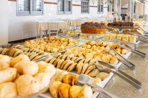 a buffet filled with different types of pastries and desserts at Rondinha Hotel in Arroio do Sal