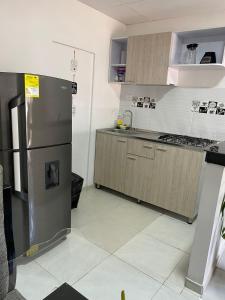 uma cozinha com um frigorífico de aço inoxidável e armários em Mami Yola em Valledupar