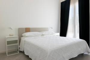 a bedroom with a white bed and a window at Sa Pasadina in Àrbatax