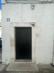 a black door on the side of a white building at Casa Sunshine in Ostuni