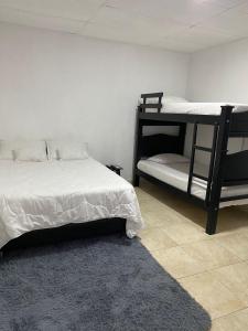 1 dormitorio con 2 literas y alfombra en Mami Yola en Valledupar