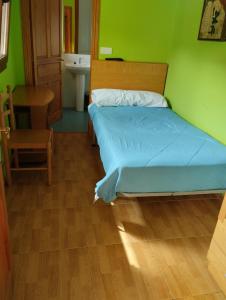 a bedroom with a bed and a table and a sink at Habitaciones Restaurante Asador el Puente Galdames in San Pedro de Galdames +68 photos
