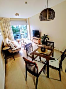 a living room with a glass table and chairs at Avenida Aconquija Suites in Yerba Buena