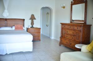 1 dormitorio con cama, tocador y espejo en The Harbour, en Rodney Bay Village