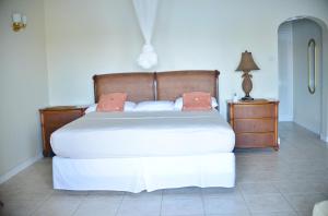 um quarto com uma cama grande e uma mesa de cabeceira em The Harbour em Rodney Bay Village