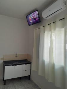 a room with a tv on the ceiling and a curtain at Pousada Ebenezer in Andradina