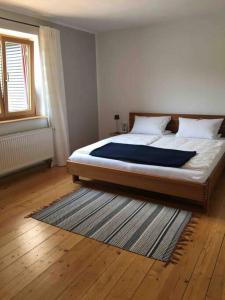 a bedroom with a bed and a rug on the floor at KampenZeit Ferienwohnung-traumhafter Panoramablick in Aschau im Chiemgau