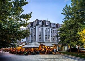 a large building with tables and chairs in front of it at Hotel Splendid in Pleven