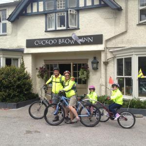 um grupo de pessoas em bicicletas em frente a um edifício em The Cuckoo Brow Inn em Far Sawrey