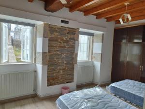 1 dormitorio con 2 camas y pared de piedra en Lazzaretto vivienda uso turístico, en Lugo