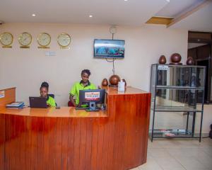 two people sitting at a counter with their laptops at Ubuntu Palace Hotel in Kampala