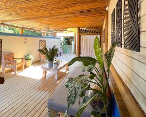 a porch with a bench and plants on a deck at VELINN Pousada Iguana Azul in Ilhabela