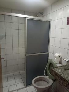 a bathroom with a toilet with a shower door at Boreas Apart Hotel in Fortaleza