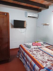 a bedroom with a bed and a tv on the wall at Villamorra house in Asunción