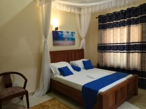 1 dormitorio con 1 cama, 1 silla y 1 ventana en 5 Bedroom Villa Near Pride Inn, en Mombasa
