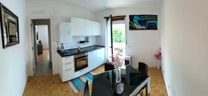 a kitchen with white cabinets and a table in it at IL PAITITI in Arco