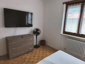 een slaapkamer met een dressoir en een flatscreen-tv bij IL PAITITI in Arco