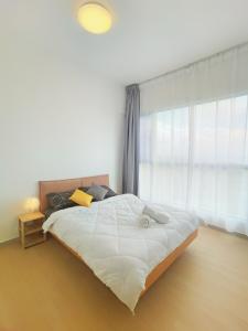 a bedroom with a large white bed with a window at Super Comfort 2R2B Luxury Seaview Sandakan in Sandakan