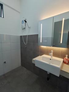 La salle de bains est pourvue d'un lavabo blanc et d'un miroir. dans l'établissement Super Comfort 2R2B Luxury Seaview Sandakan, à Sandakan