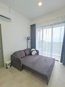 - un canapé dans le salon doté d'une grande fenêtre dans l'établissement Super Comfort 2R2B Luxury Seaview Sandakan, à Sandakan