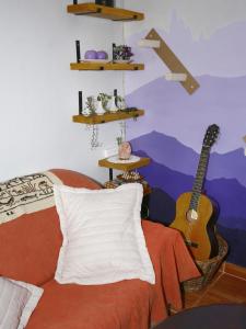 a room with a bed and a guitar on the wall at Lago Argentino B&B in El Calafate