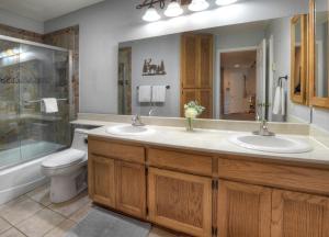 a bathroom with two sinks and a shower and a toilet at Silverpick Condo #304 in Durango Mountain Resort +34 photos