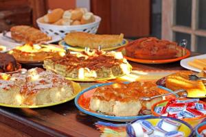 una mesa llena de diferentes tipos de pasteles y repostería en VELINN Pousada Iguana Azul, en Ilhabela