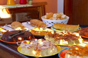 una mesa con muchos tipos diferentes de pasteles y repostería en VELINN Pousada Iguana Azul, en Ilhabela