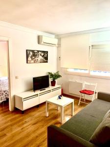 a living room with a couch and a tv at Ana's Apartment parking gratuito in Málaga