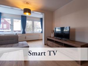 a living room with a tv and a couch at Haus an der Skiwiese-Braunlage in Braunlage