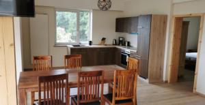 a kitchen with a wooden table and wooden chairs at Natur Pur Ferienhaus Falkenhagen in Thale