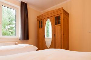 a bedroom with a wooden cabinet next to a bed at Natur Pur Ferienhaus Falkenhagen in Thale
