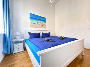 una camera da letto con un grande letto con lenzuola blu di Große 3-Raum Luxus-Unterkunft mit 2 Bädern, Waschtrockner & kostenfreier Tiefgarage in Innenstadtnähe a Lipsia