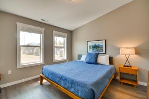 - une chambre avec un lit bleu et 2 fenêtres dans l'établissement Vivid Home on Red Lodge Mountain Golf Course!, à Red Lodge
